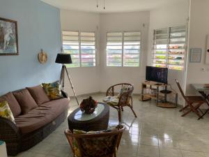 a living room with a couch and a table at Villa l'Exotik in Les Abymes