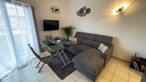 ein Wohnzimmer mit einem Sofa und einem Tisch in der Unterkunft Addis in Salon-de-Provence