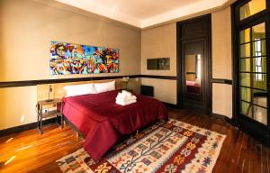 Un dormitorio con una cama y un cuadro en la pared. en Maison Ramón, en Buenos Aires