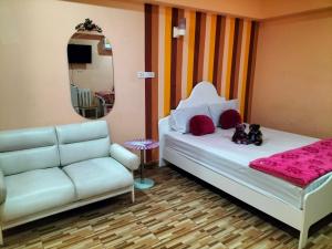 1 dormitorio con cama, sofá y espejo en P Place พีเพลส ห้องพักรายวัน, en Bangkok