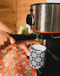 a person is making a cup of coffee at Wild Monkey Hostel in Cuenca