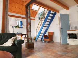 een woonkamer met een blauwe deur en een trap bij de Dars in Callantsoog