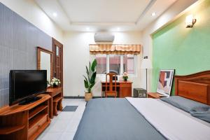 a bedroom with a large bed and a flat screen tv at Sen Vivian Home in Ho Chi Minh City
