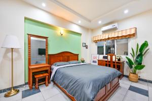 a bedroom with a bed and a desk and a window at Sen Vivian Home in Ho Chi Minh City