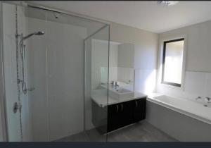 a bathroom with a shower and a sink and a tub at Gibbagunyah Manor Workers Accommodation Only in Muswellbrook