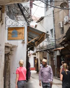 a group of people walking down a narrow street at Emerald Palm in Zanzibar City