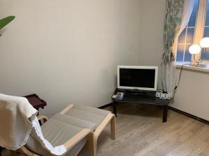 橿原市宿や　サニービレッジ的一间房间,配有椅子和一张桌子上的电脑