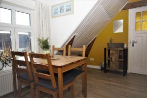 una sala da pranzo con tavolo in legno e scala di B&B 'T Skoalhûs a Westergeest
