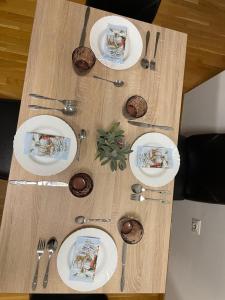 a table with white plates and silverware on it at Big Apartment with private parking - EXTRA VIEW in Skopje