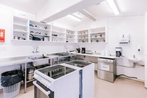 une cuisine avec des comptoirs et des placards blancs dans l'établissement Hlíd Hostel, à Mývatn