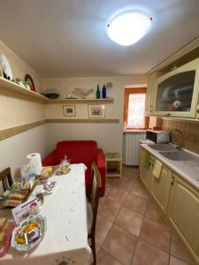 a kitchen with a white table and a red couch at Antico Borgo in Fornelli