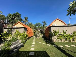 un jardín con 2 casas y una valla en Kubu River View en Ambengan