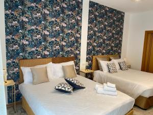 2 Betten in einem Zimmer mit Blumentapete in der Unterkunft Suite Fimabechi in Bari