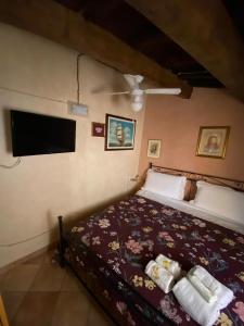 a bedroom with a bed and a flat screen tv at Antico Borgo in Fornelli