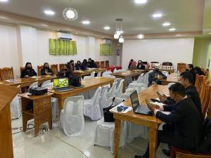 un grupo de personas sentadas en mesas en un aula en Elnora Delmar Travellers Inn en Siquijor