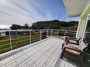 a balcony with two chairs and a view of the ocean at JEJU Doldam B&B in Seogwipo
