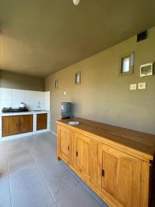 a large kitchen with a large wooden counter top at Kubu River View in Ambengan