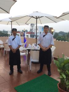 two men standing in front of a table with an umbrella at Beverly Hotel in Chennai