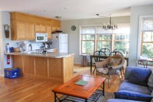 a kitchen and living room with a couch and a table at Waterfront Delight at Spindle Point in Meredith +40 photos