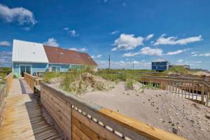 a house on a beach with a wooden fence at Return To The Beach in North Topsail Beach