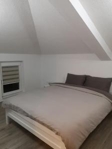 białe łóżko w pokoju z oknem w obiekcie Papi Apartments w mieście Kruszewo