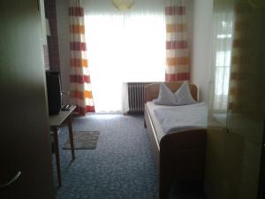 a hotel room with a bed and a window at Pension Stanek in Hofkirchen