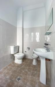 Un baño blanco con inodoro y lavabo. en Maison Ramón, en Buenos Aires 90 fotos más