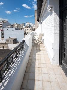 Un balcón con sillas al costado de un edificio. en Maison Ramón, en Buenos Aires