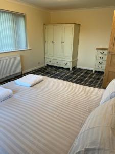 - une chambre avec un grand lit et une commode dans l'établissement The Poplars, à Bridlington