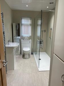 La salle de bains est pourvue de toilettes, d'une douche et d'un lavabo. dans l'établissement The Poplars, à Bridlington