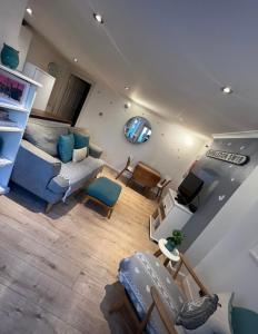 einen Blick über ein Wohnzimmer mit einem blauen Sofa in der Unterkunft Stunning, peaceful entire flat in the centre of Wimbledon in London
