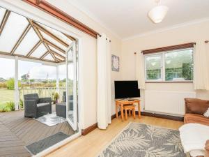 a living room with a couch and a television at The Station Masters Lodge in Hayle