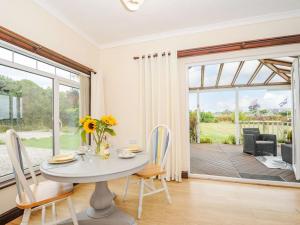 a dining room with a table and a large window at The Station Masters Lodge in Hayle