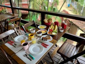 una mesa con platos de comida y bebidas. en Pousada Paloma, en Abraão