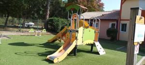 a playground with a slide in a yard at chalet Le Ticaco Soustons plage in Soustons