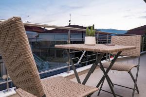 einen Tisch und zwei Stühle auf dem Balkon in der Unterkunft Quattro Luxury Apartments in Tríkala