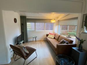 - un salon avec un canapé et une chaise dans l'établissement Huisje56, à Zoutelande