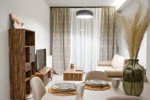 ein Wohnzimmer mit einem Tisch und einem Sofa in der Unterkunft Quattro Luxury Apartments in Tríkala