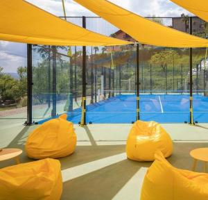 a tennis court with yellow covers and a tennis court at Agriturismo Villa Paradiso Esotico in Città di Castello