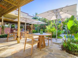 un patio con mesas, sillas y sombrillas en Sala Beach House en Ballito