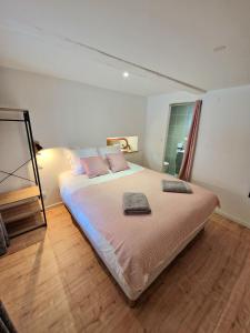 una camera da letto con un grande letto con cuscini rosa di Home La Petite Porte - Petite Venise - Colmar a Colmar