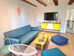 a living room with a blue couch and a tv at Home La Petite Porte - Petite Venise - Colmar in Colmar