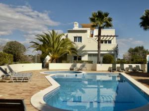 eine Villa mit einem Pool vor einem Haus in der Unterkunft Casa Marinha Beach in Lagoa