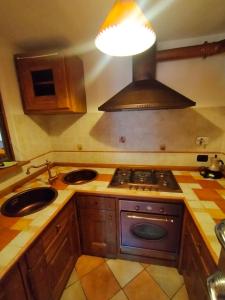 a kitchen with a stove and a sink and a light at Au Coeur de Saint Nicolas in Saint Nicolas