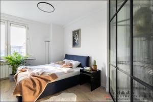 Schlafzimmer mit einem Bett mit blauem Kopfteil in der Unterkunft P&O Apartments Bitwy Warszawskiej - Ochota in Warschau