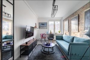 ein Wohnzimmer mit einem blauen Sofa und einem Tisch in der Unterkunft P&O Apartments Bitwy Warszawskiej - Ochota in Warschau