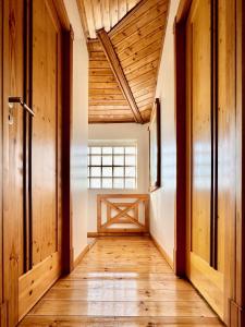 a hallway of a house with wooden floors and a window at Casa do Rio Alva in Arganil