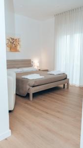 1 dormitorio con 2 camas y suelo de madera en Guesthouse Aschenez, en Reggio Calabria