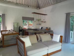 a living room with a couch and a kitchen at Balian Bliss Retreat Bungalow & Villas in Balian