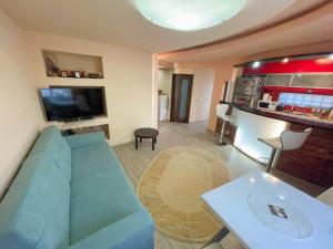 uma sala de estar com um sofá azul e uma televisão em Ultracentral Lozonschi 2 rooms apartment em Iaşi